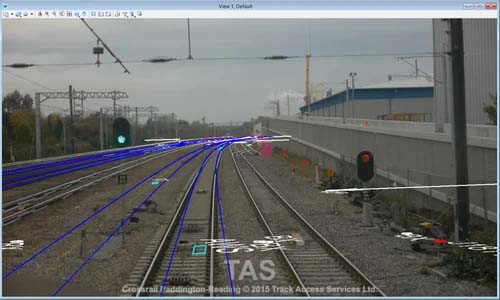 A rail yard with multiple train tracks and visible signals. Blue lines and annotations, likely from MicroStation, are overlaid on the image, indicating analysis or tracking data for better infrastructure. Part of a building and an electricity tower are in the background. | Bentley Systems | Infrastructure Engineering Software Company A rail yard with multiple train tracks and visible signals. Blue lines and annotations, likely from MicroStation, are overlaid on the image, indicating analysis or tracking data for better infrastructure. Part of a building and an electricity tower are in the background.