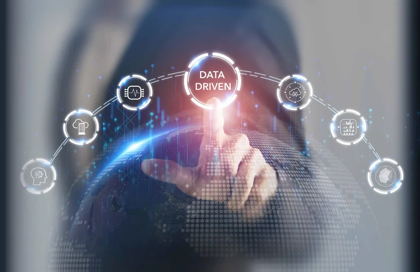 a guy in a suit touching a screen that has text thats says Data Driven with other tech icons around it