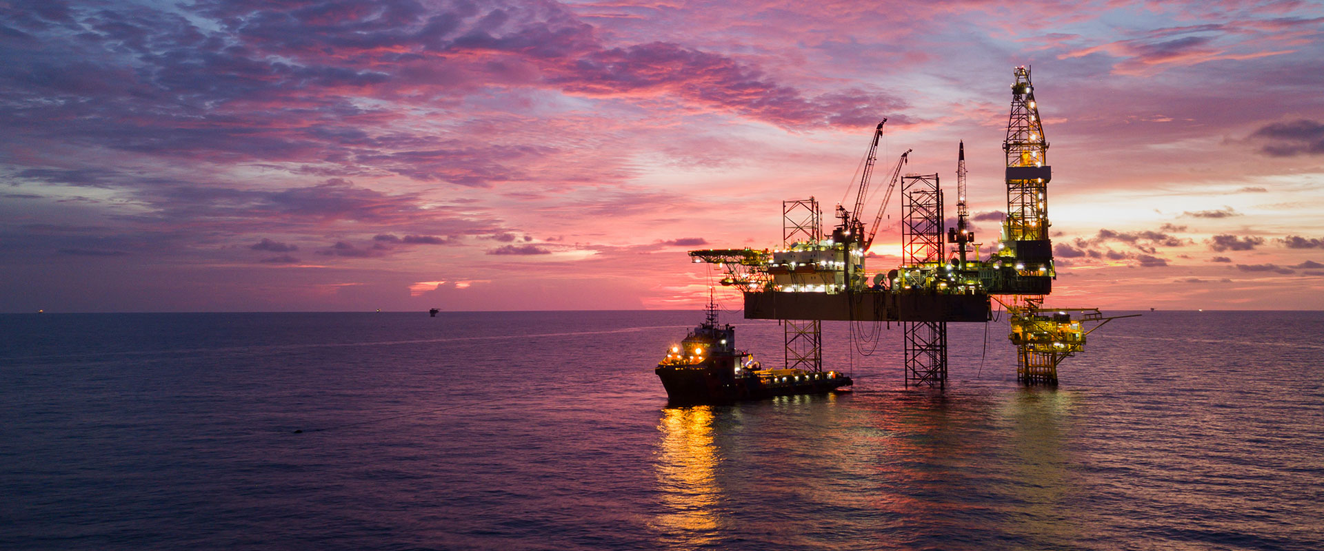 Aerial view offshore drilling rig (jack up rig) at the offshore location during sunset